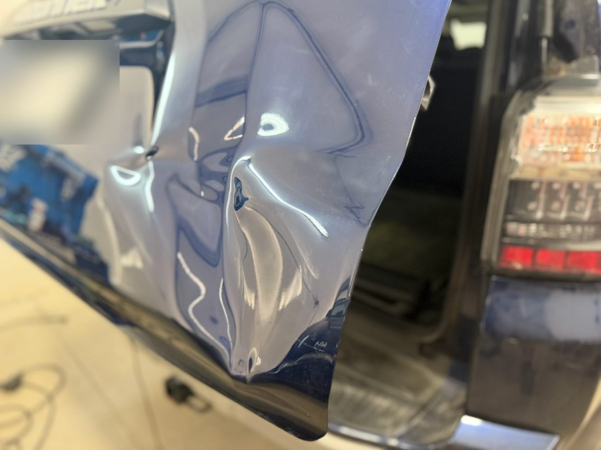 Dented liftgate of a blue Toyota 4Runner